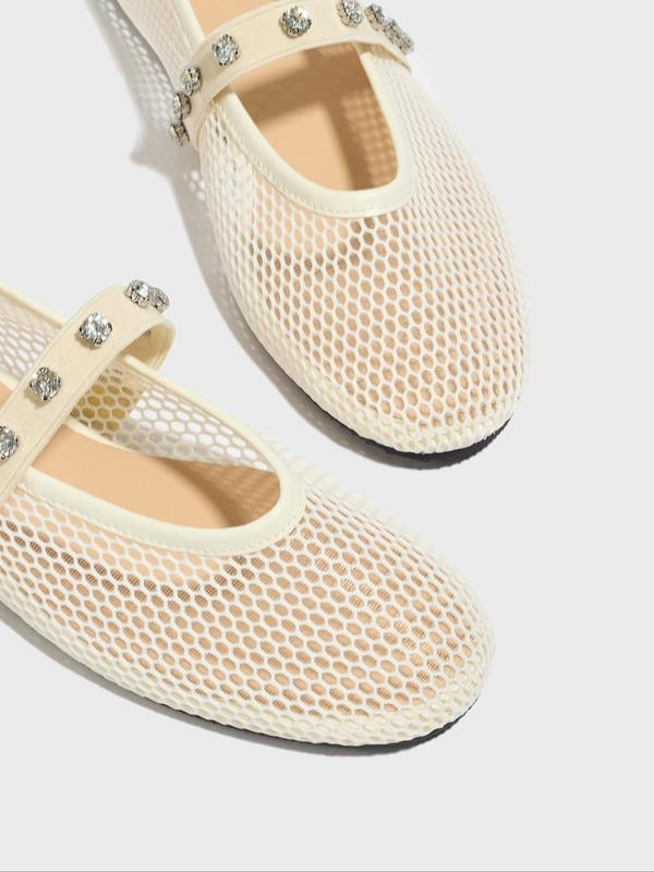 Cream-colored mesh shoes with embellishments on a white background