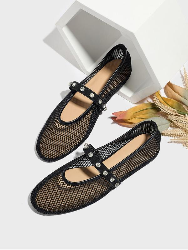Black mesh shoes with decorative straps on a white background