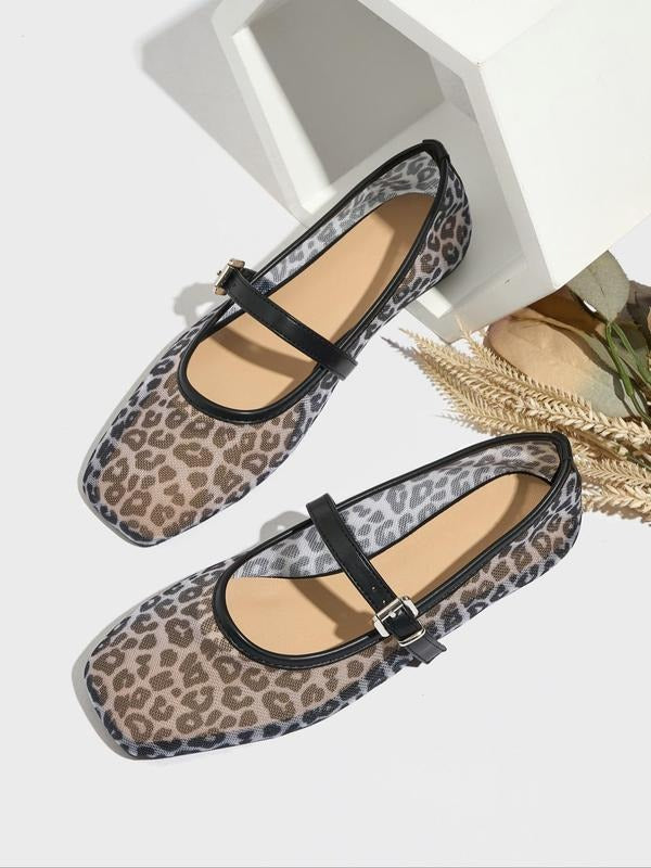 Pair of leopard print flats with black straps on a white background
