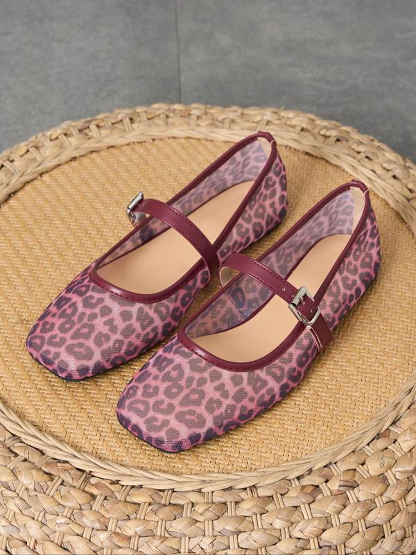 Pair of leopard print shoes with a strap on a woven mat