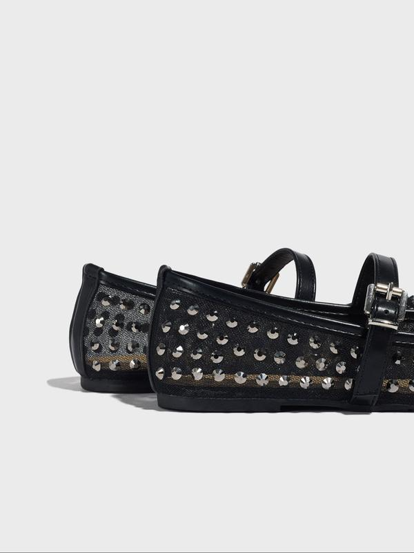 Black studded shoes on a light gray background