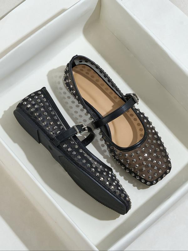 Black studded flats on a white background