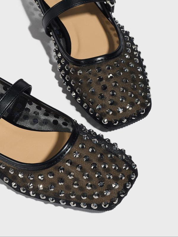 Black studded shoes on a light gray background