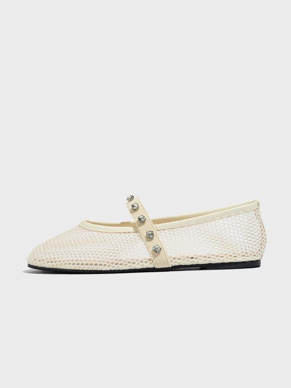 White woven flat shoe with embellishments on a white background