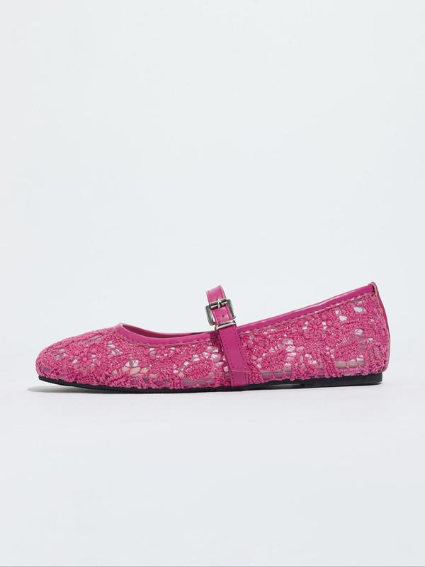 Pink flat shoe with a strap on a white background