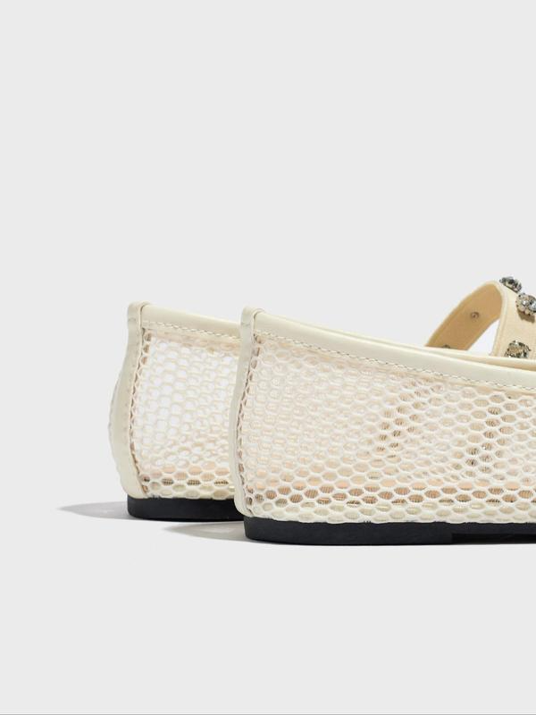 White mesh shoes with black soles on a light gray background