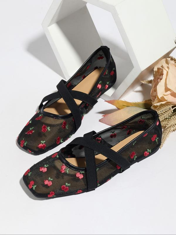 Black floral mesh flats with criss-cross straps on a white background
