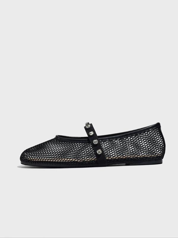 Black mesh flat shoe with decorative strap on a white background