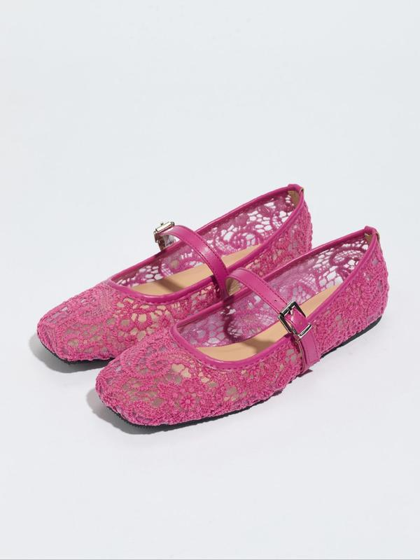 Pair of pink lace shoes with buckles on a white background