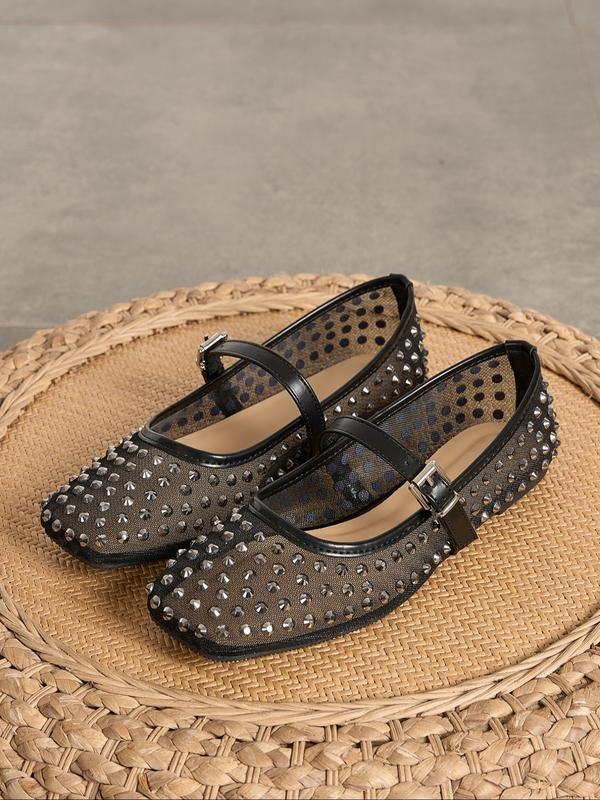 Black studded flats on a woven surface